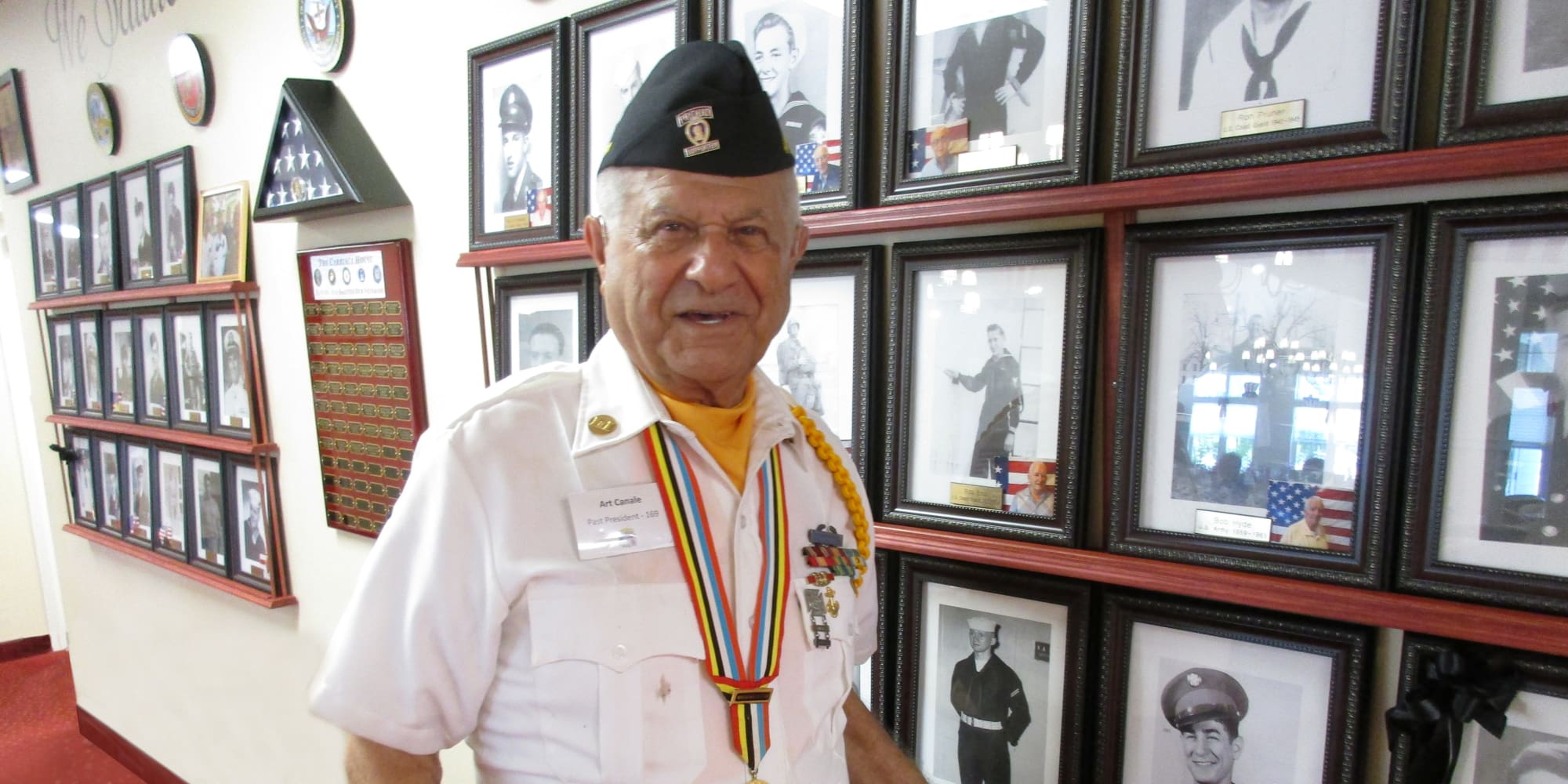 A veteran resident next to his photo at The Carriage House Gracious Retirement Living in Oxford, Florida