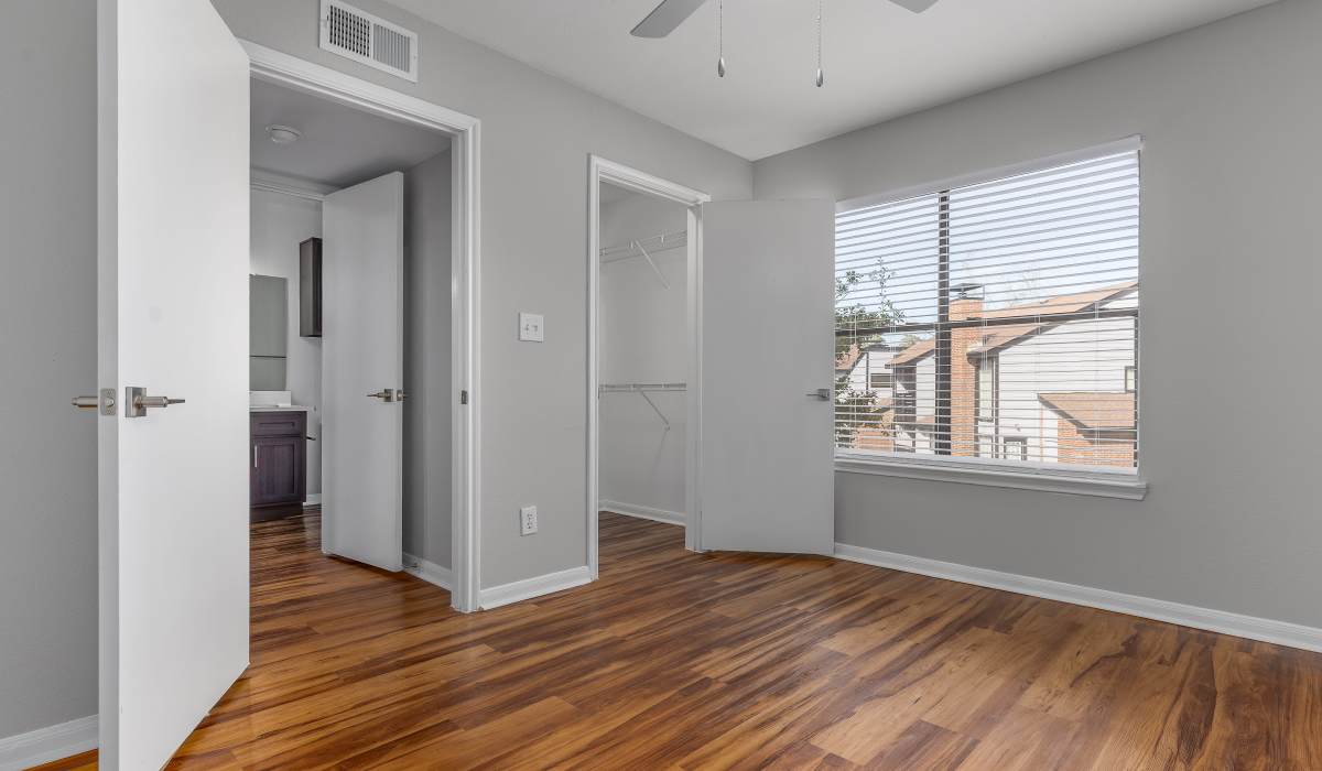 Room with wood flooring and multiple doors at Oaks of Kingwood Apartments in Kingwood, Texas