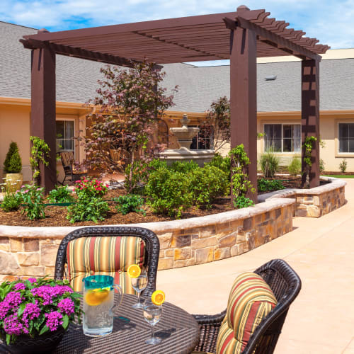 Patio chairs and planter boxes outside at Saddlebrook Oxford Memory Care in Frisco, Texas