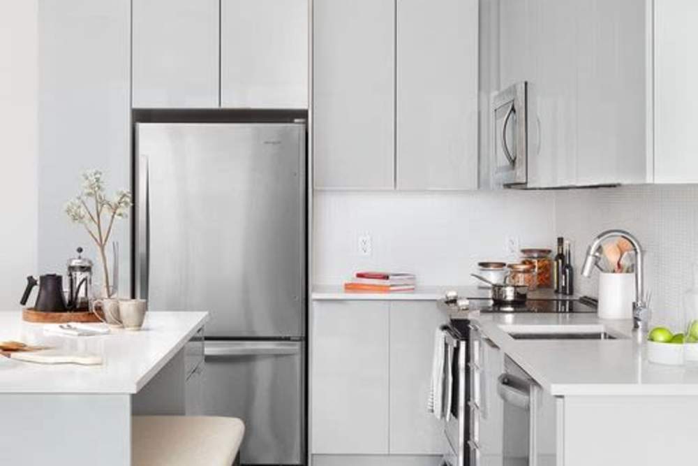 Fully-equipped kitchen with stainless steel appliances and refridgerator at Ardan in Dallas, Texas