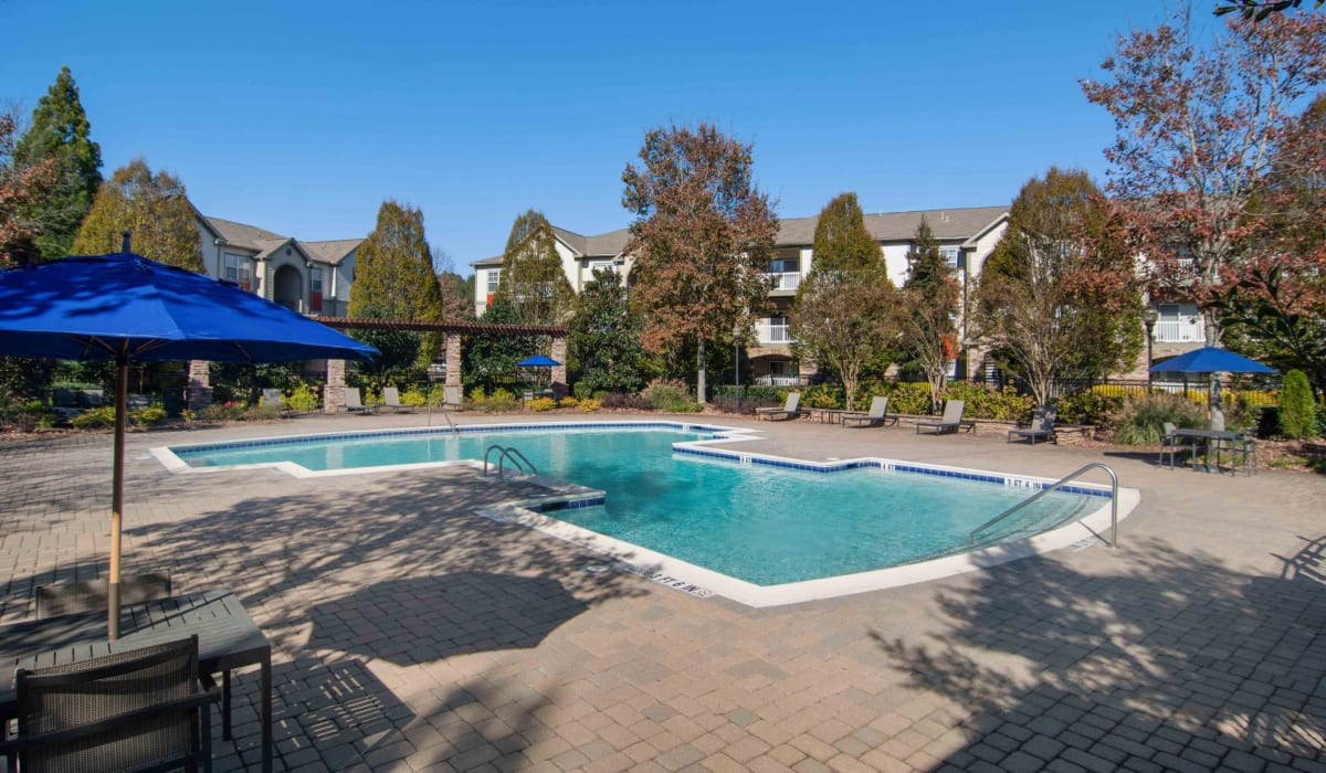 Swimming pool with patio and poolside umbrellas at Alta Mill Apartments, Austell, Georgia