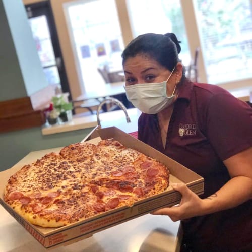 Team member saerving pizza at Oxford Senior Living in Wichita, Kansas