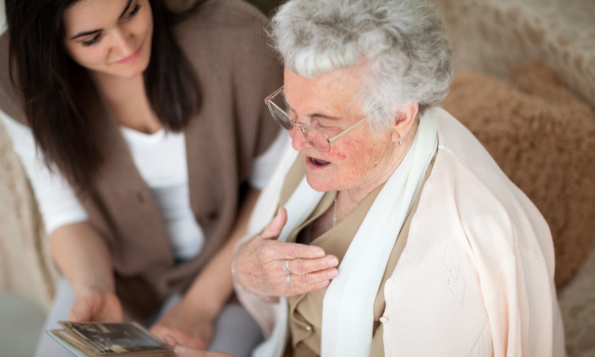Caregiver and resident look at pictures together at Broadwell Senior Living in Plymouth, Minnesota