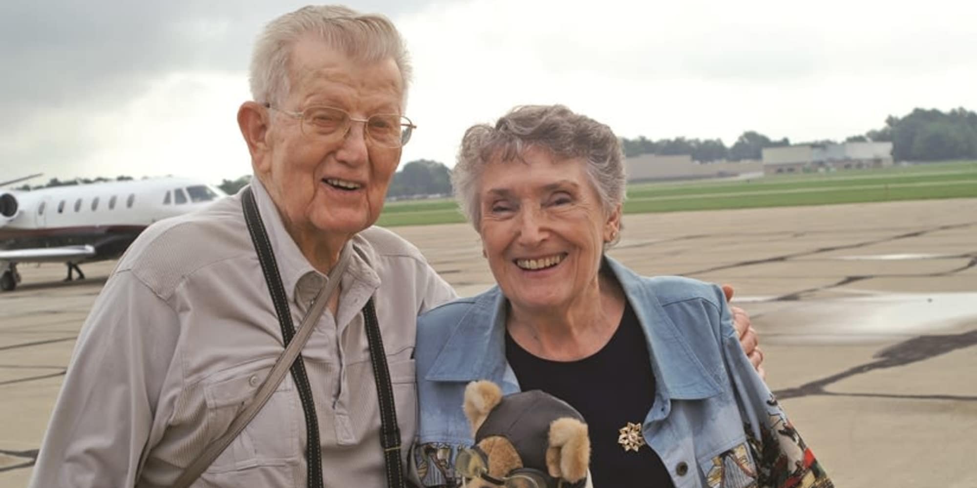 Two residents from Heritage Meadows Gracious Retirement Living in Cambridge, Ontario posing in front of a plane