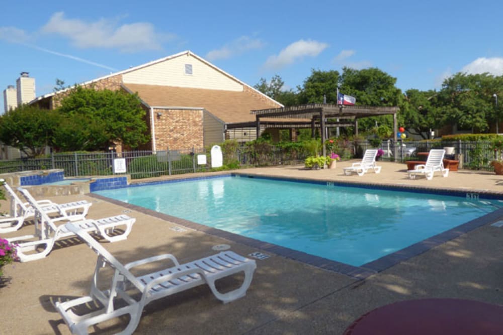 Sparkling swimming pool surrounded by lounge chairs at Crystal Ridge in Midlothian, Texas