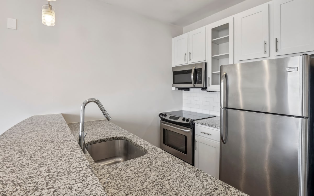 Granite counters and stainless steel appliances of kitchen at Terraces at Manchester in Richmond, Virginia