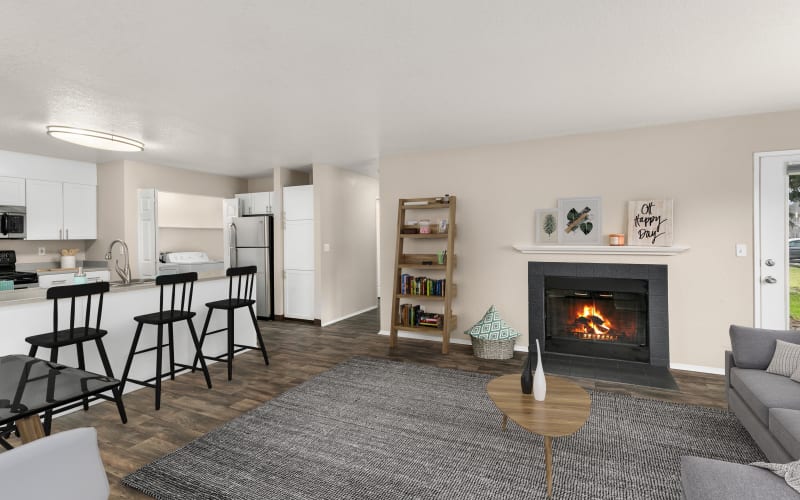 Spacious living room with a fireplace and hardwood-style floors at Carriage Park Apartments in Vancouver, Washington