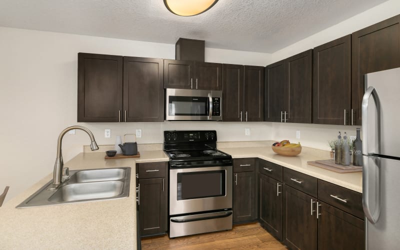 Beautifully renovated kitchen with espresso cabinetry and stainless steel appliances at Carriage Park Apartments in Vancouver, Washington