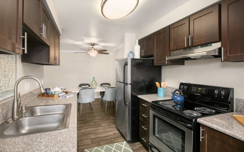 Espresso cabinets in the kitchen overlooking the dining room at Walnut Grove Landing Apartments in Vancouver, Washington