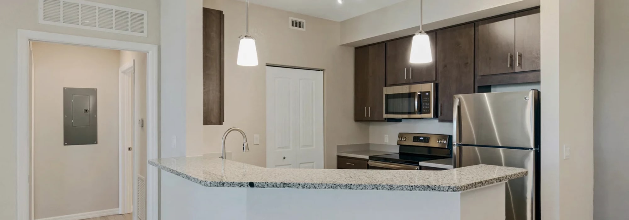 Modern kitchen with sleek stainless steel appliances and elegant granite countertops at Lemon Bay Apartments in Englewood, Florida.