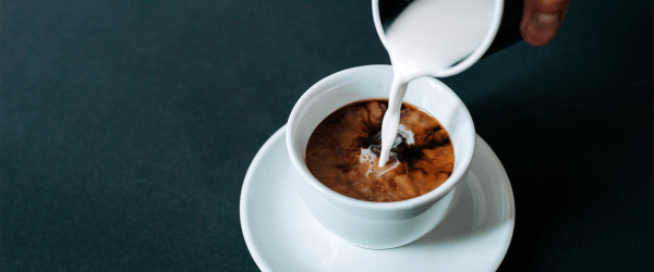 Coffee cup with cream being poured in coffee at The Compass at Springdale Park in Richmond, Virginia