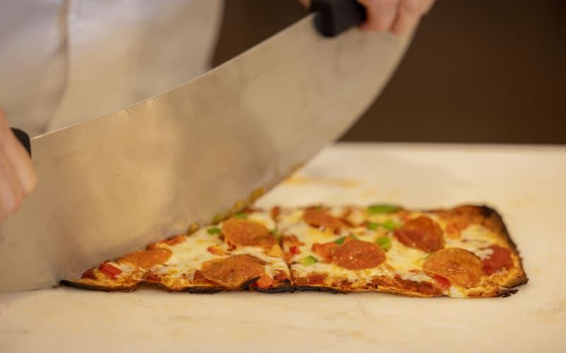 Chef cutting a pizza at The Barclay at St. Augustine in St. Augustine, Florida