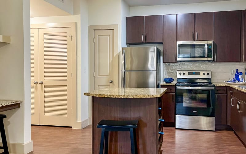 Renovated kitchen with white cabinets and black and stainless steel appliances at Broadstone Grand Avenue in Pflugerville, Texas