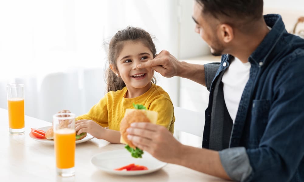 Father and daughter eating lunch at their Viva Communities home in Florida