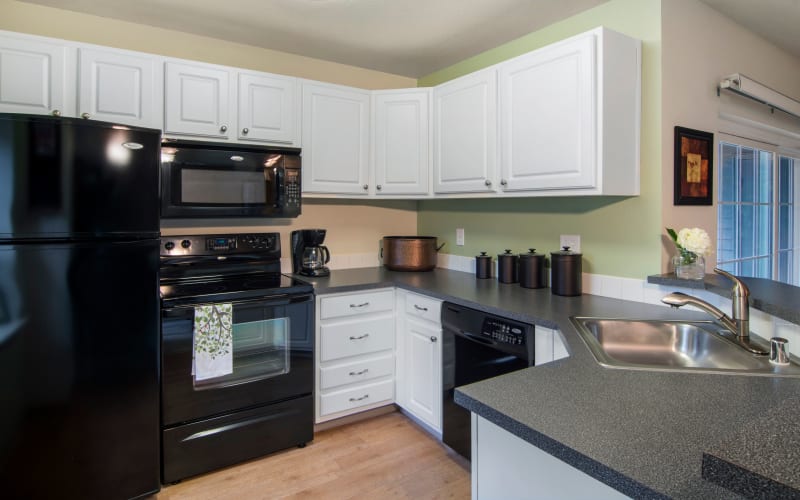 Black appliances and white cabinets in a renovated kitchen at Autumn Chase Apartments in Vancouver, Washington