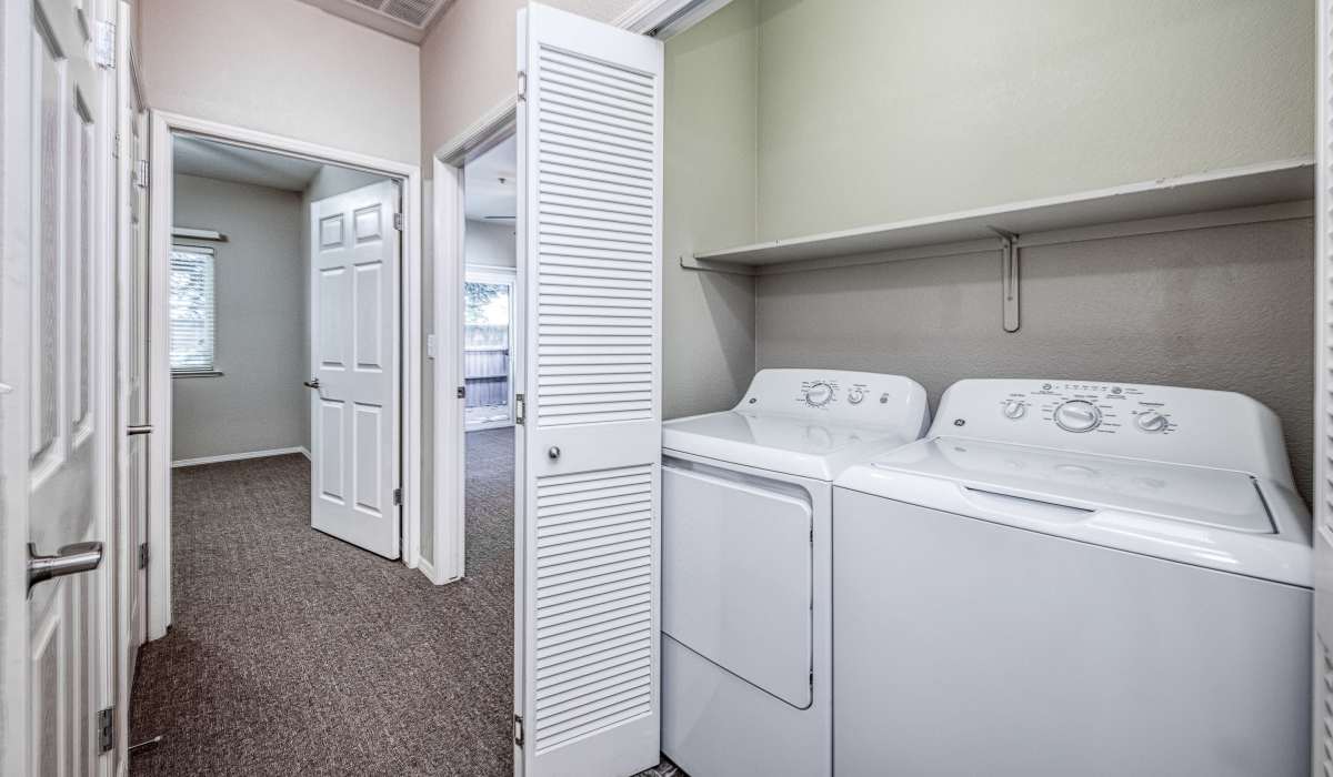 A view of the laundry with washer and dryer at Westwood Bluffs in Fresno, California