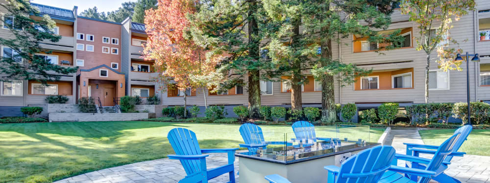 Adirondack chairs surround a fire pit at Serramonte Ridge Apartment Homes in Daly City, California