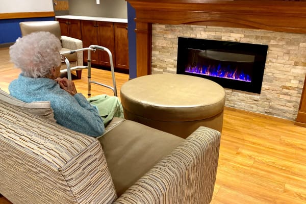 Senior woman seating on a comfortable couch at Belle Reve Senior Living in Milford, Pennsylvania