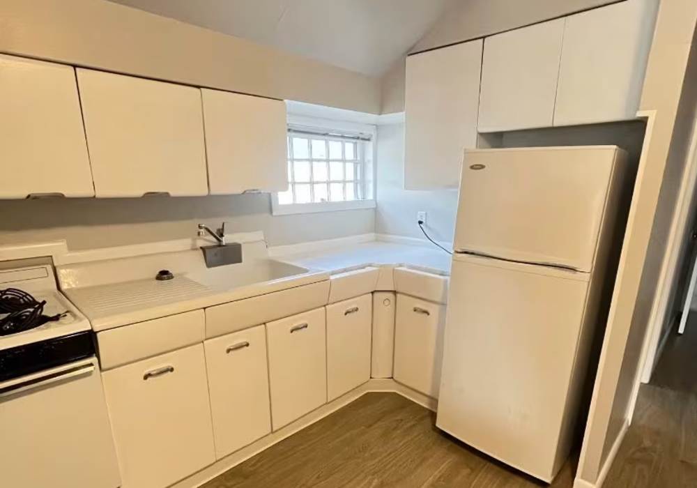 Kitchen with white appliances and hardwood flooring at Westminster Apartments in Spokane, Washington