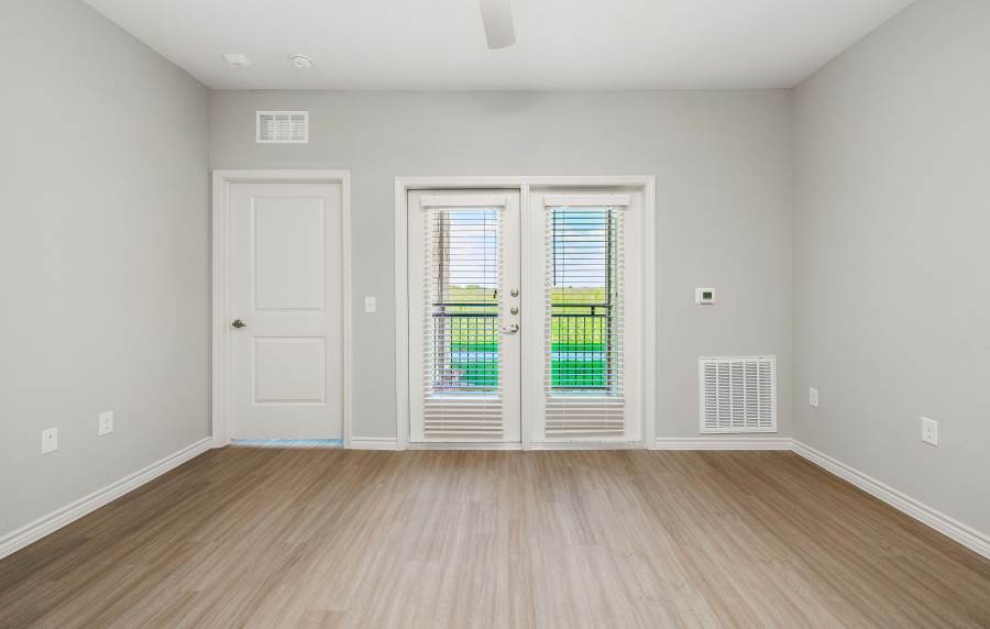 Bright living room with balcony access at Redwood in San Marcos, Texas