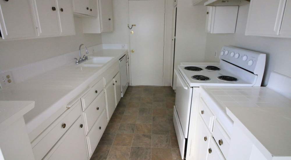 Kitchen with white appliances and cabinetry at Regency in Sherman Oaks, California