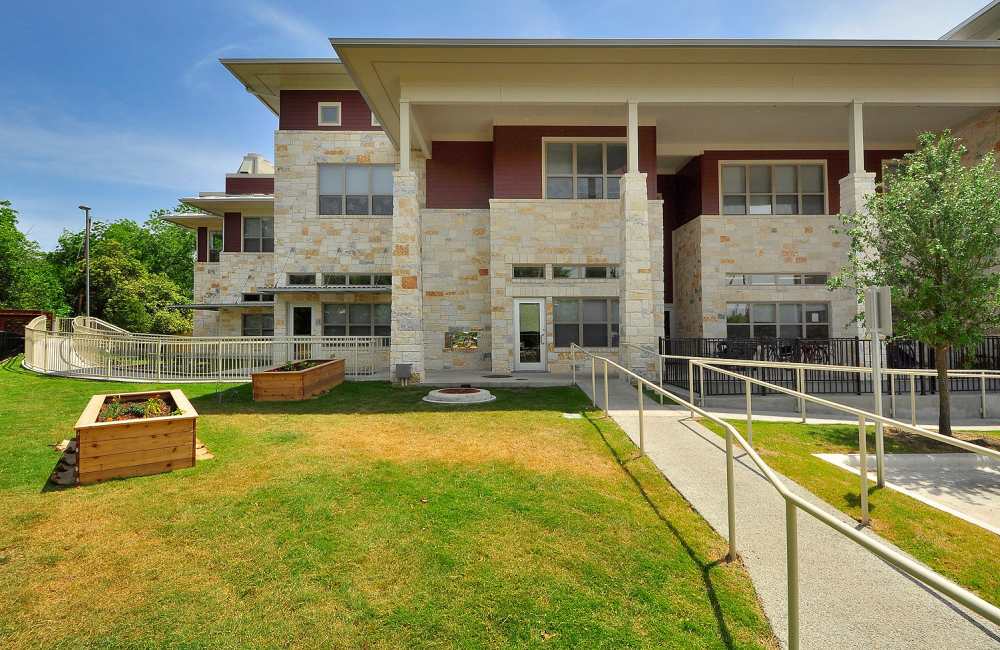 Community exterior with green lawn at M Station in Austin, Texas, 