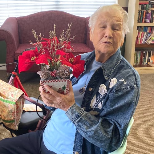 Smiling resident holding a bouquet of flowers at Canoe Brook Assisted Living in Duncan, Oklahoma