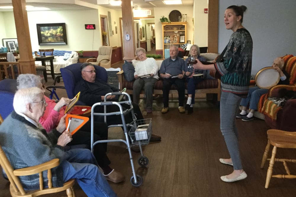 Staff member and residents playing the guitar at Prairie Hills in Independence, Iowa.