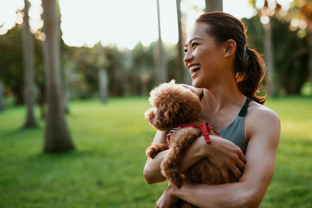 A woman walking her dog near Villas at Grand Avenue in Pflugerville, Texas