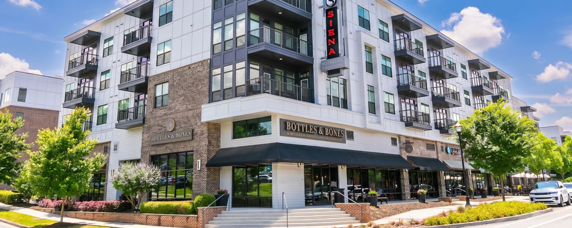 Mixed-use apartment community with ground-floor retail and balconies at Siena Suwanee Town Center in Suwanee, Georgia