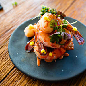 Gourmet shrimp dish topped with fresh herbs and vibrant garnishes at Pomona Apartments in Ocala, Florida