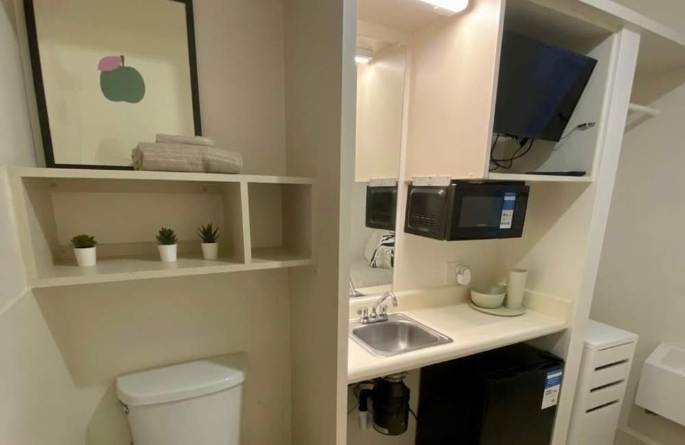 Small kitchen space and tv area of studio apartment at Trolley Court in San Diego, California