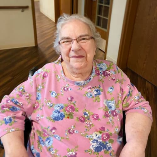 Sitting resident smiling at the camera inside The Oxford Grand Assisted Living & Memory Care in McKinney, Texas