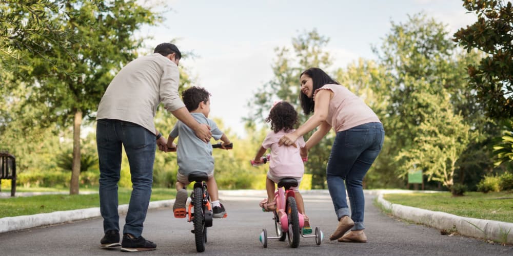 Happy family enjoying the weather and biking near Noble on the Lake in Brighton, Michigan