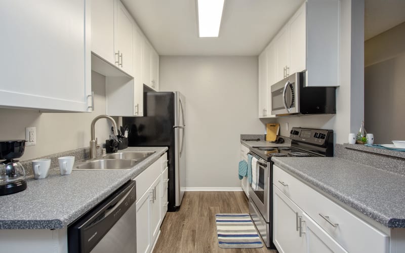 White cabinets in a renovated kitchen with stainless steel appliances at Shadow Ridge Apartments in Oceanside, California