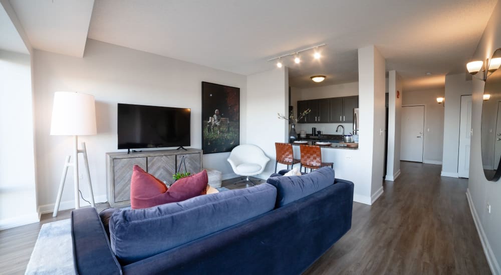 Blue couch and a comfortable chair in a model home's living space at 415 Premier Apartments in Evanston, Illinois