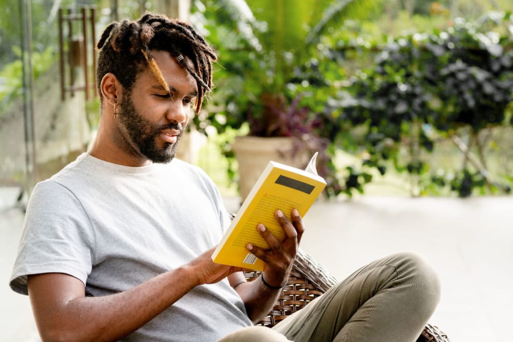 Resident reading a book outside at Elms at the Refuge in Laurel, Maryland