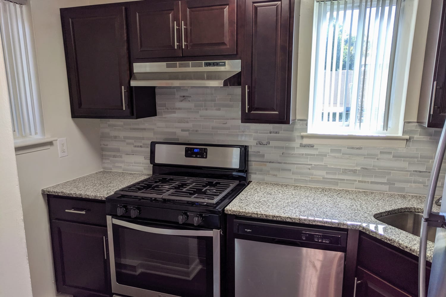 Kitchen with stainless-steel appliances and espresso cabinetry at Curren Terrace in Norristown, Pennsylvania