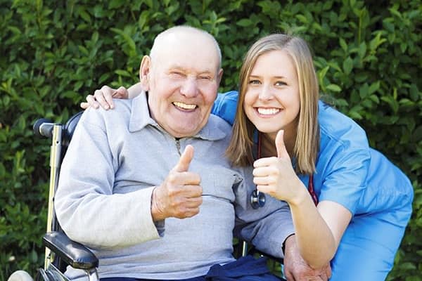 A resident and a caretaker giving a thumbs up at The Birches at Newtown in Newtown, Pennsylvania