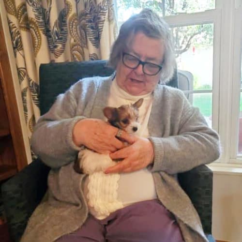 A resident holding a very small dog at Creekside Village in Ponca City, Oklahoma