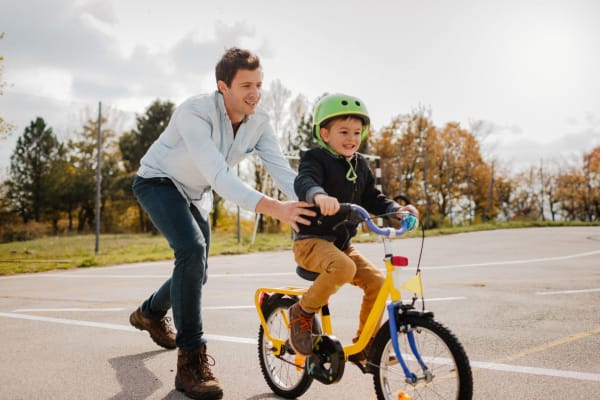 A resident pushing his child on a bike near Commons at Briarwood Park in Brookhaven, Georgia