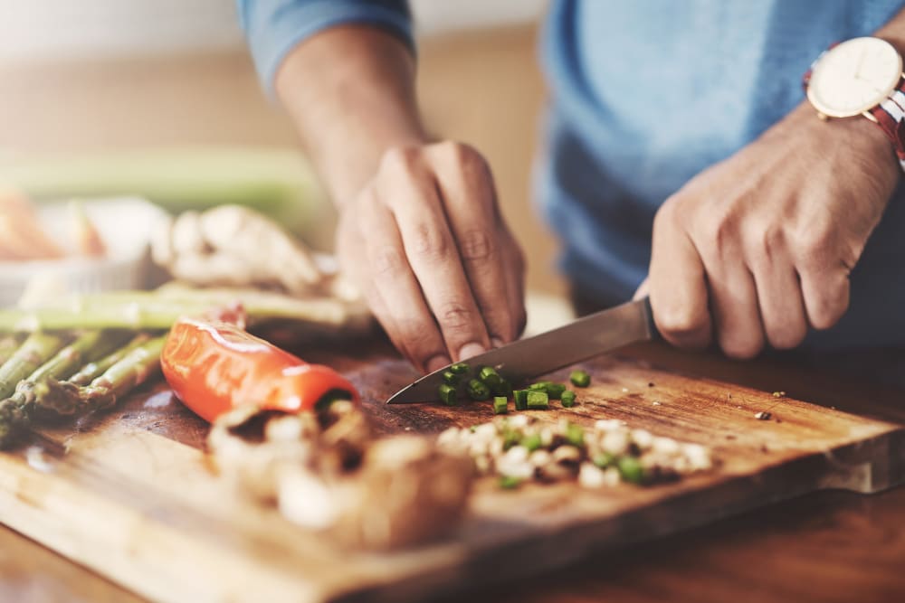 A man cooking a meal in his apartment at Skyecrest Apartments in Lakewood, Colorado