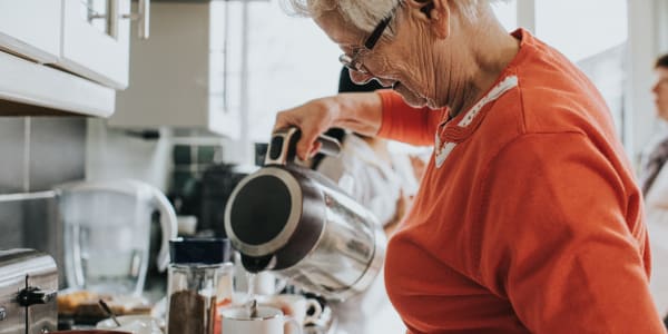 Resident pouring herself some water for a cup of tea at Fair Oaks Health Care Center in Crystal Lake, Illinois