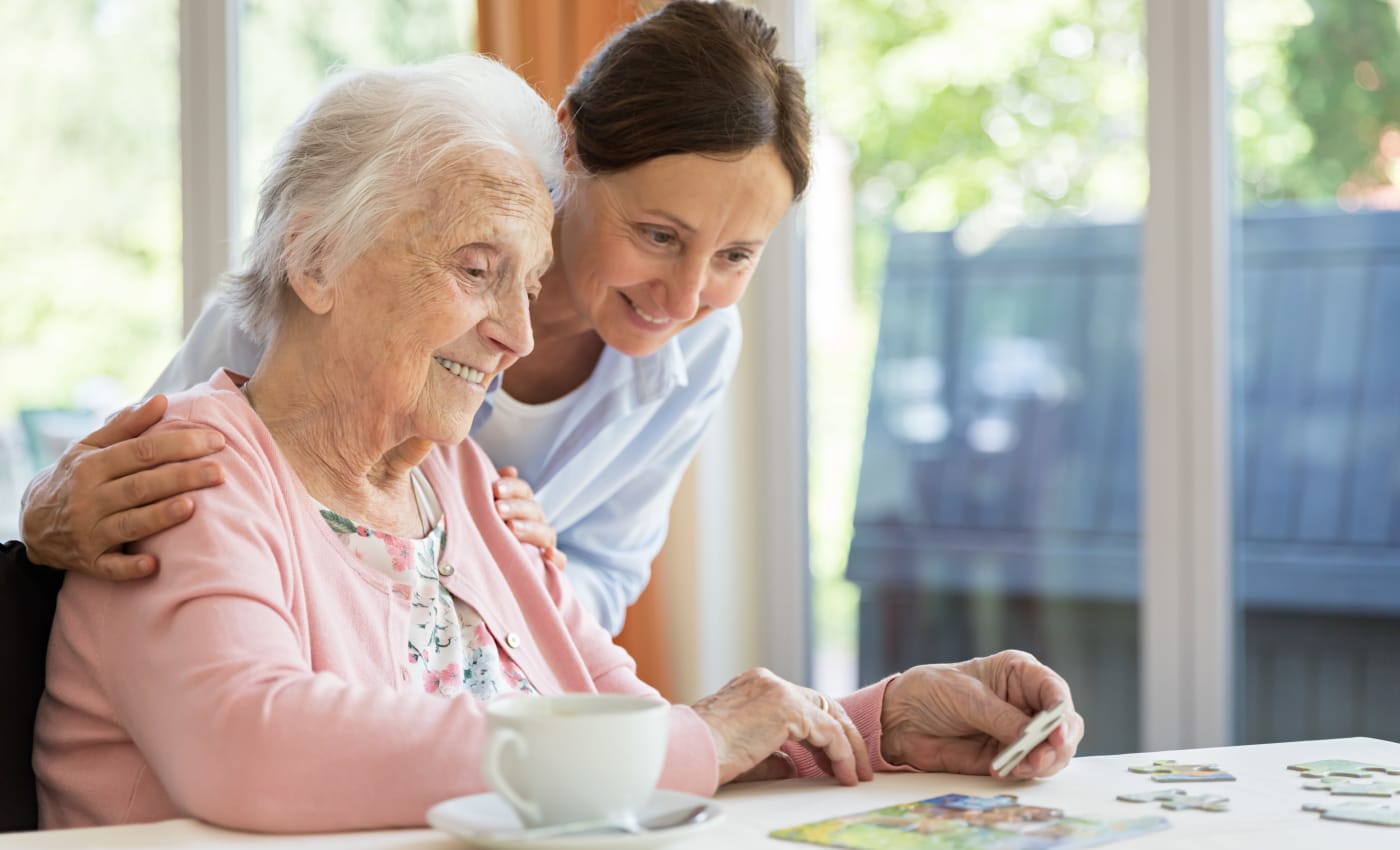 Staff member helping a resident finish a puzzle at Willows Landing in Monticello, Minnesota.