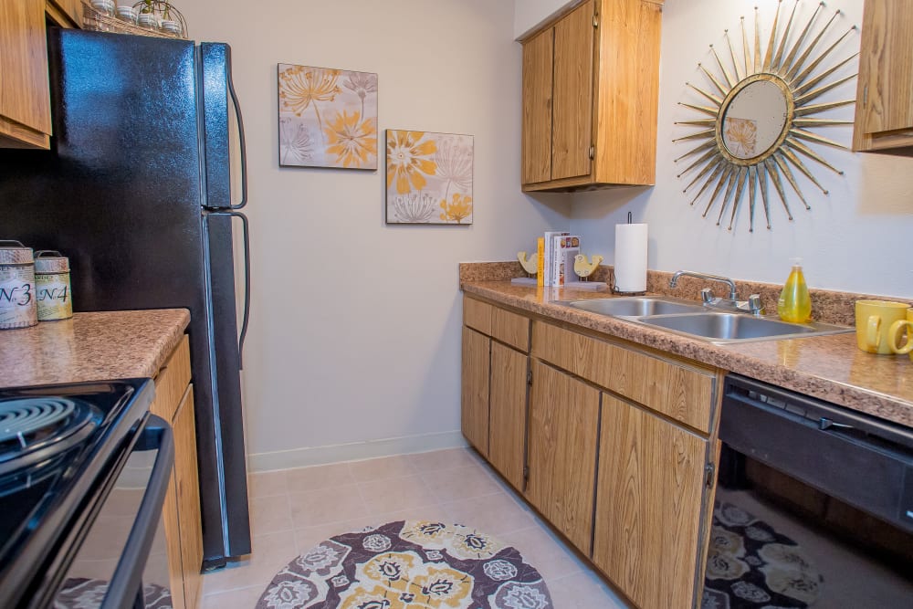 Modern kitchen with granite-style countertops in model home at The Greens of Bedford in Tulsa, Oklahoma