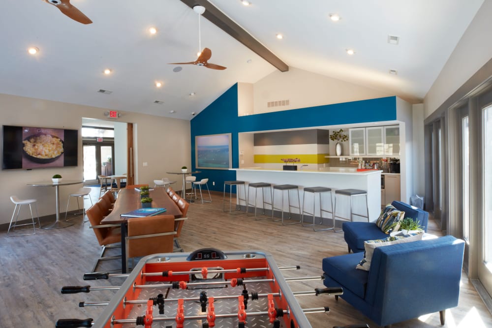 Resident lounge with foosball table and kitchen at Lakeside Terraces in Sterling Heights, Michigan