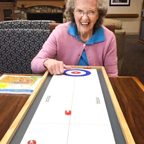 Resident playing shuffleboard at Glen Carr House Memory Care in Derby, Kansas