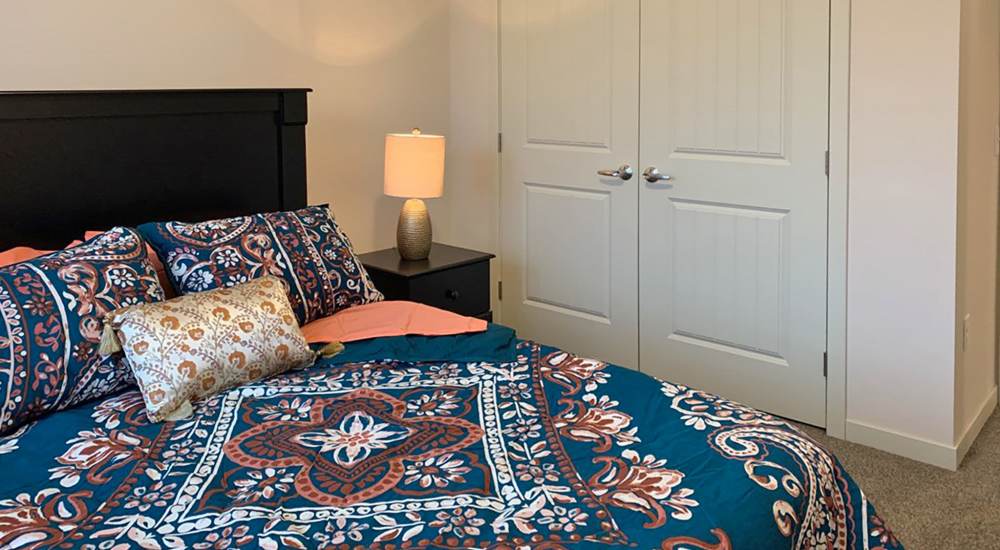 Bedroom with a comfortable bed, side lamps and closet at Depot on Main in Zimmerman, Minnesota