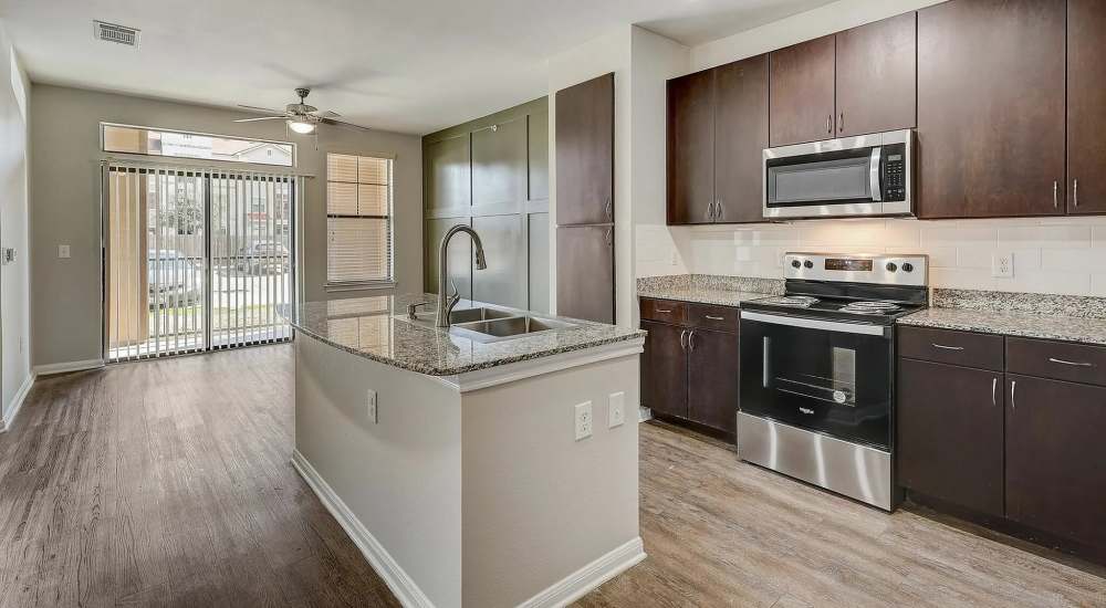 Gourmet kitchen with island and granite counters at The Milo on Westheimer in Houston, Texas