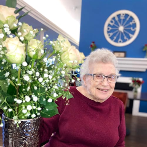 Assisted Living resident smiling with flowers at Madison House in Norfolk, Nebraska